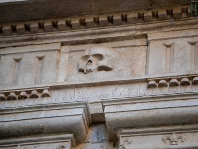 Nel piano inferiore � delimitata da coppie di lesene di ordine dorico che sorreggono una cornice con fregio arricchito da triglifi e metope in cui si alternano teschi umani e ossa incrociate che le conferiscono un alone di lugubre inquietudine